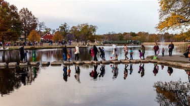 People stepping across Rose's Pond