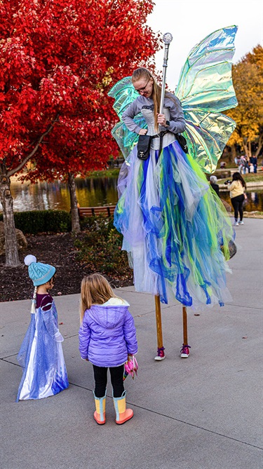 Fairy stilt walker with two girls