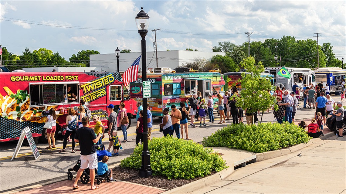 row of food trucks Old Town Lenexa with crowd of people