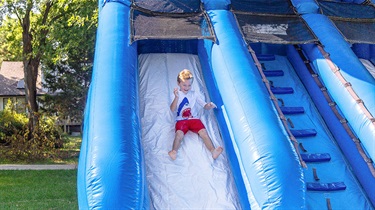 Boy goes down inflatable slide