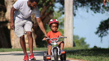 Father with young son on tricycle