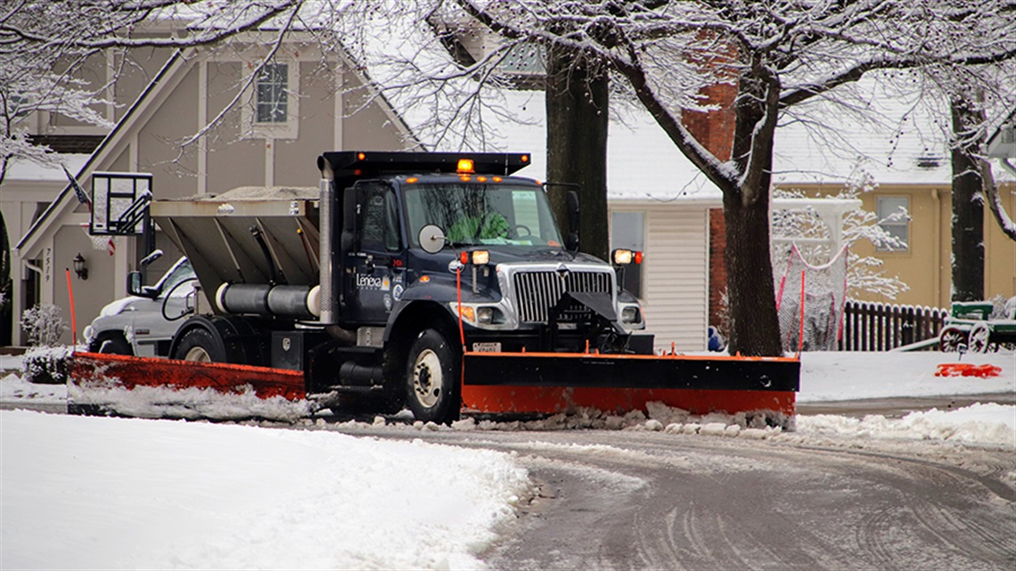 Snow plow removing snow from street