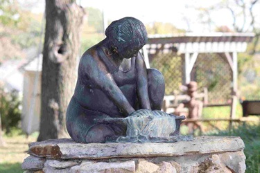 Sculpture of a woman washing clothes. Wash Day: This Fred J. Darpino sculpture was created using a warm bronze patina.