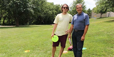 two men holding disc golf discs