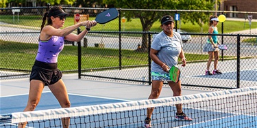 Two women playing pickleball outdoors