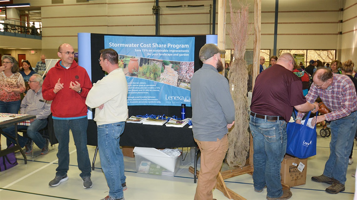 People talking at stormwater education booth at Healthy Yards Expo