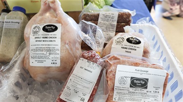 Closeup view of frozen meats on ice including chicken and sausage