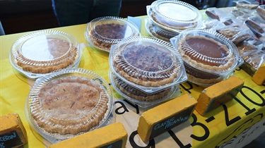 Various pies stacked on a yellow table