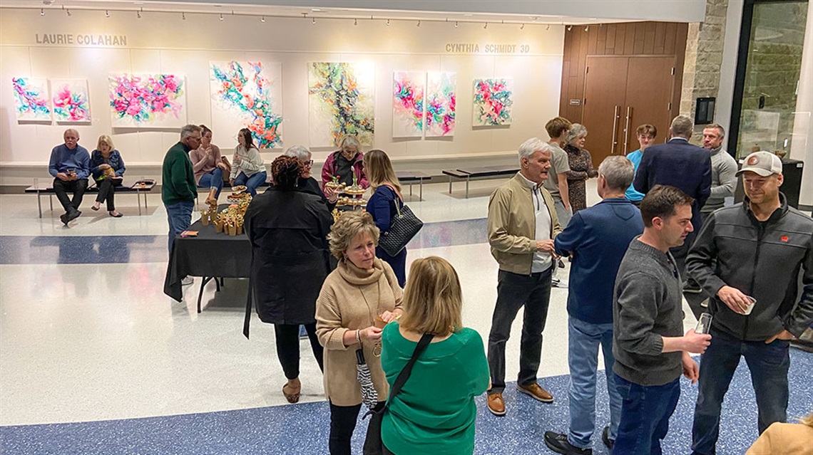 people milling around at art exhibit reception