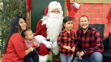 Family poses for photo with Santa Claus