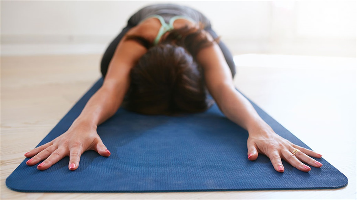 Woman doing child's pose on yoga mat