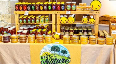 Next to Nature Farm vendor booth with honey products