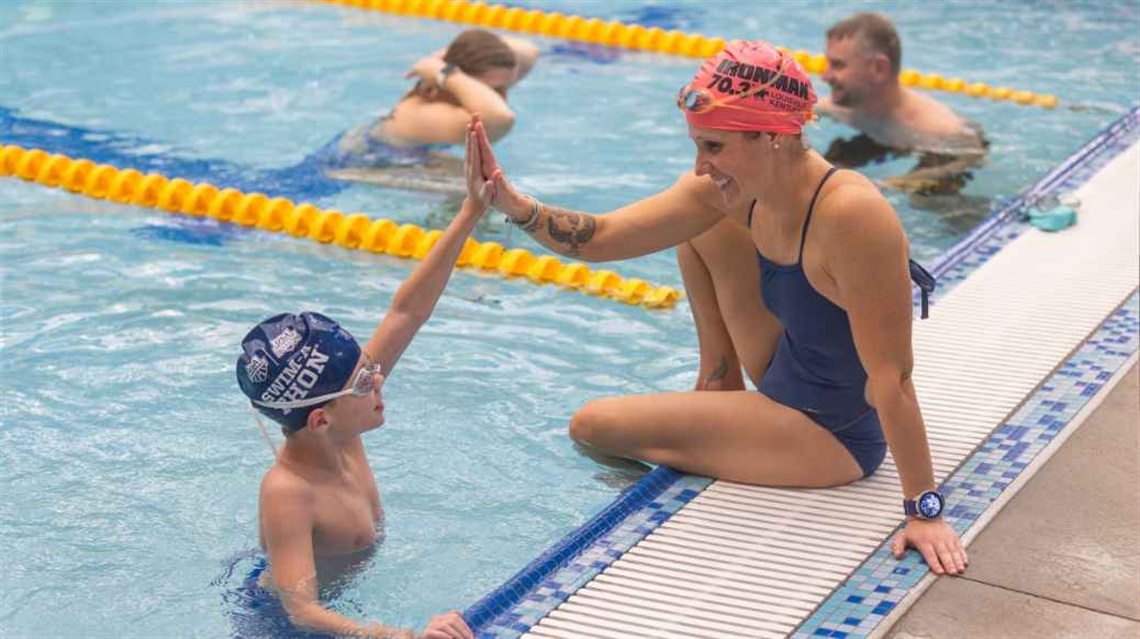 Mother and son high five at pool's edge
