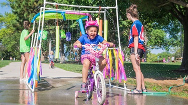 Girl rides through car wash