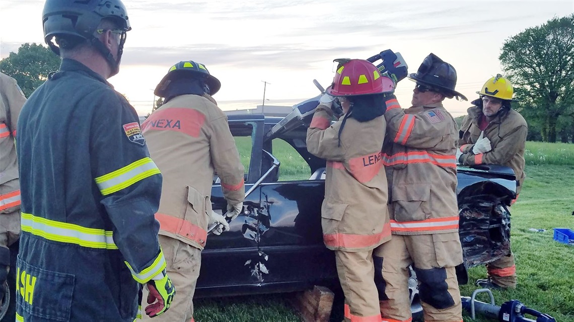 participants of academy work on crashed vehicle