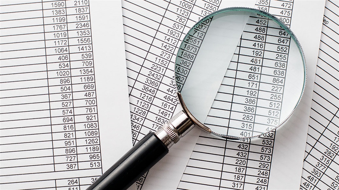 magnifying glass on spreadsheets