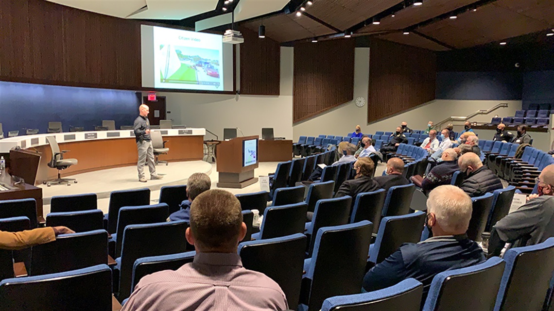 Attendees sitting in lecture hall with speaker