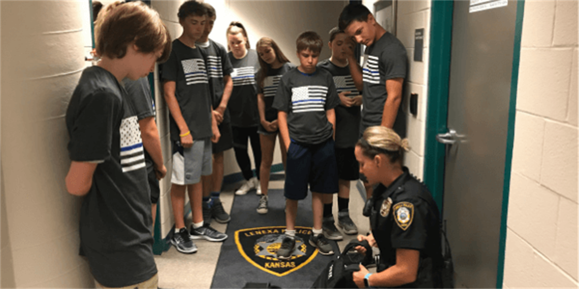 Female officer giving a tour of the police station to a group of kids