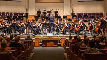 Volunteer orchestra musicians performing concert