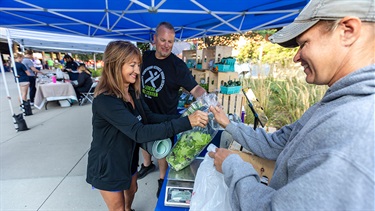 Couple buying greens from vendor