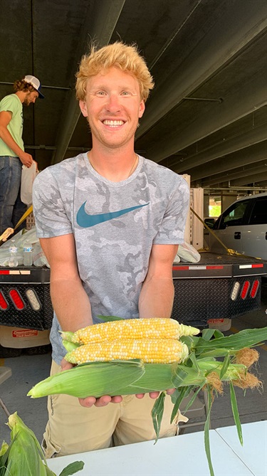 Man holding ears of corn