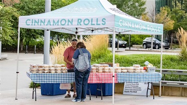 Shopper browses Mac's Cinnamon Rolls vendor booth