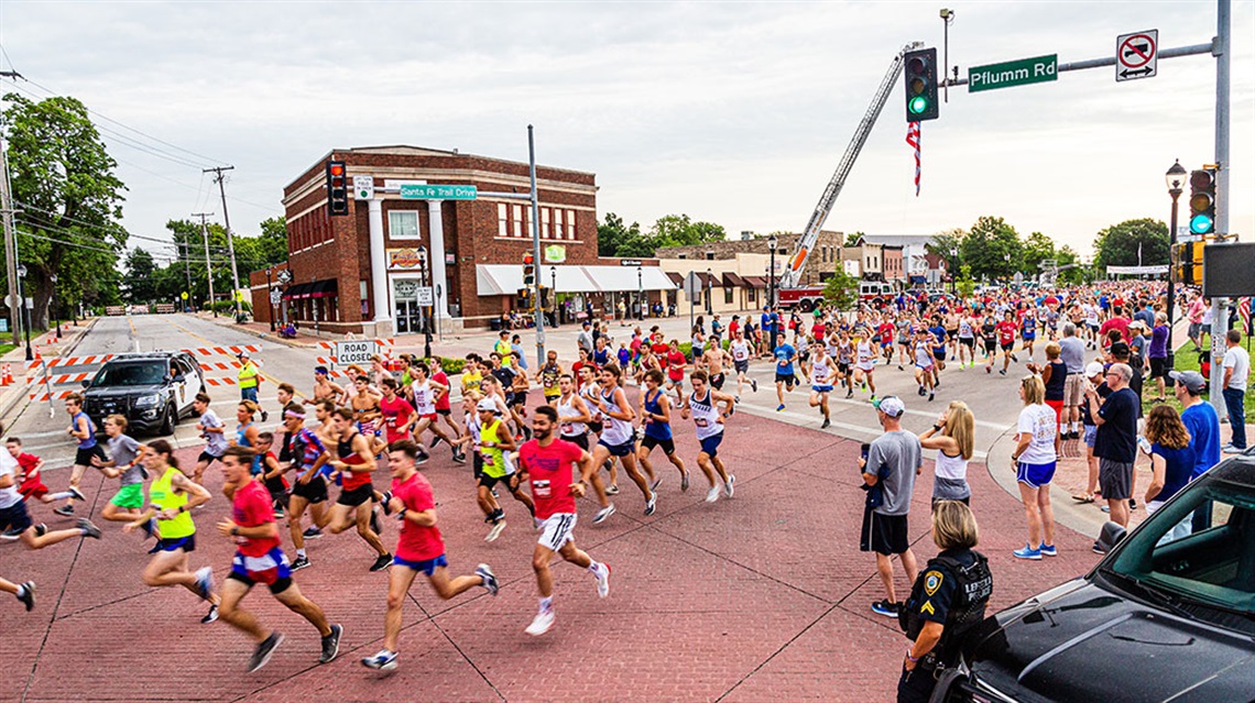 runners passing through Pflumm Road intersection in Old Town