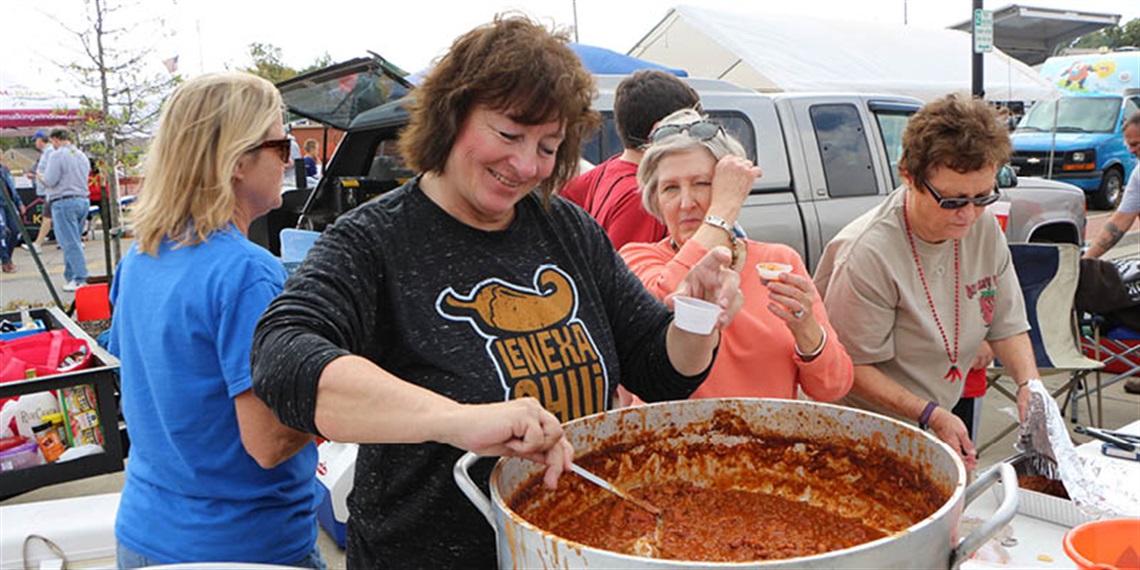 Lenexa Chili Challenge participant stirring chili in Old Town