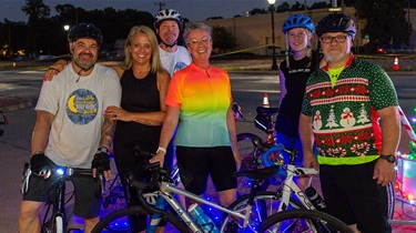 Cyclists posing with bikes at night