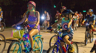 Kids riding decorated bikes at night