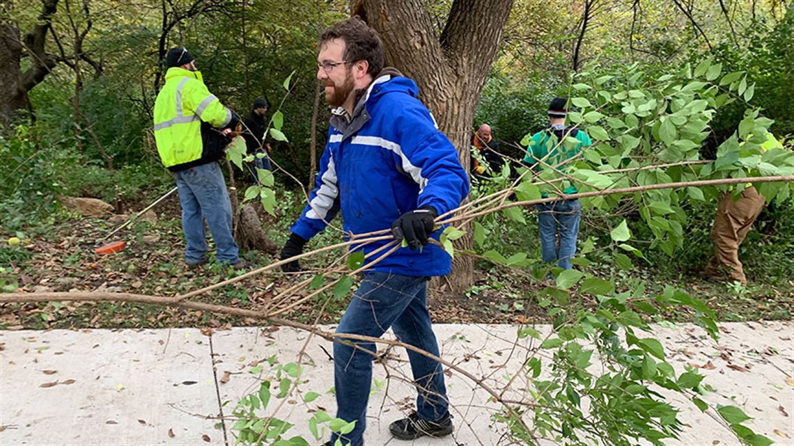 volunteers hauling leafy brush in a park