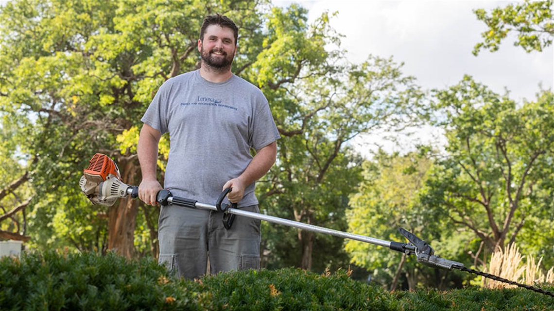 Worker outdoors with weed eater