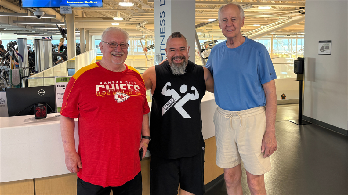 Steve Seeling, Cruz and Steve Ortmeyer smiling on the fitness floor