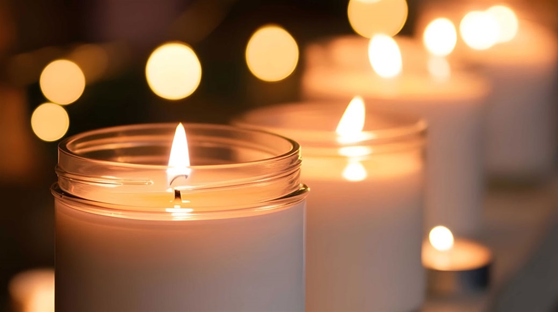 Closeup view of a row of candles in glass jars