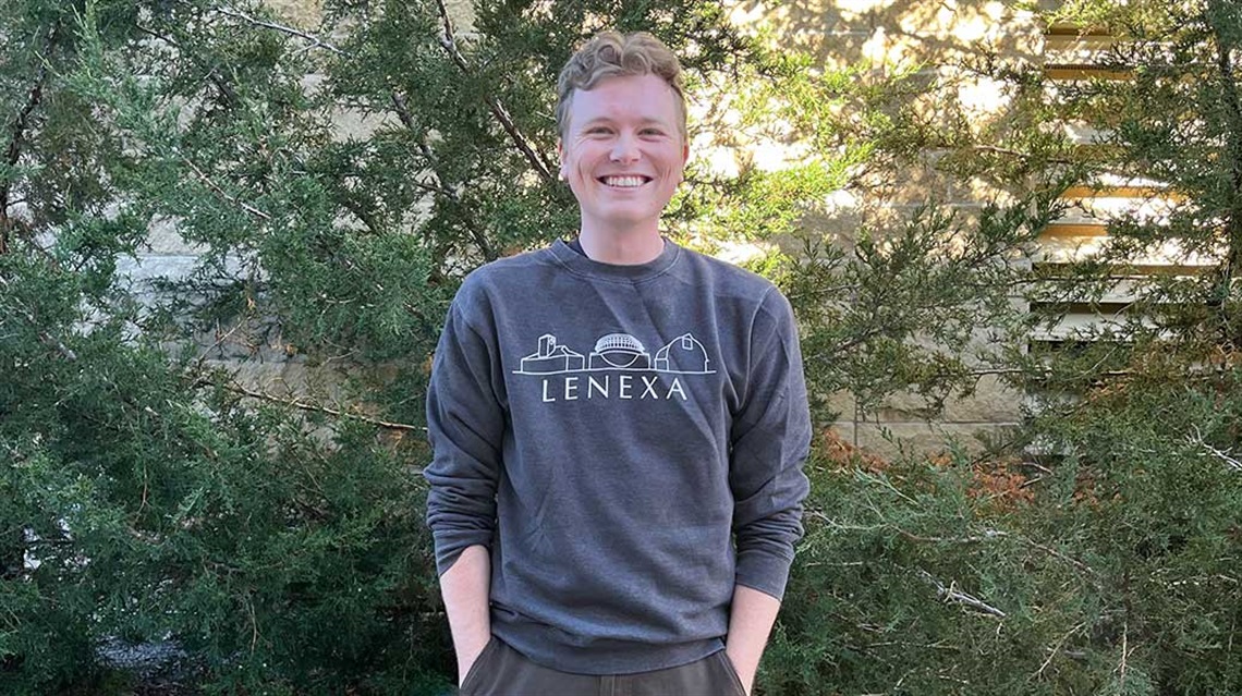 Smiling man with hands in pockets wearing Lenexa sweatshirt