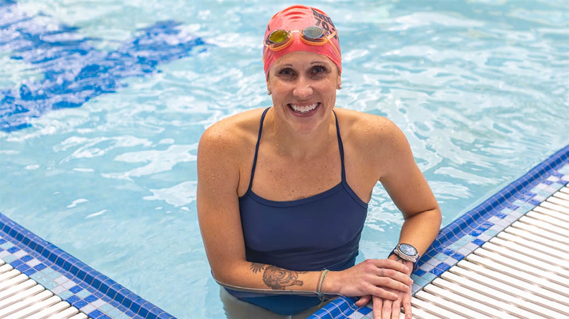 Beth smiling with swim cap and goggles on inside the Rec Center indoor pool