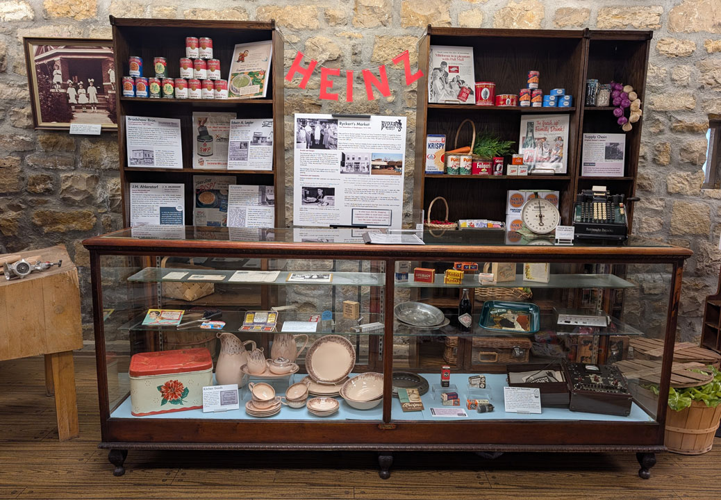 Historical exhibit about general stores in Lenexa featuring display case, shelves of products and interpretive signs