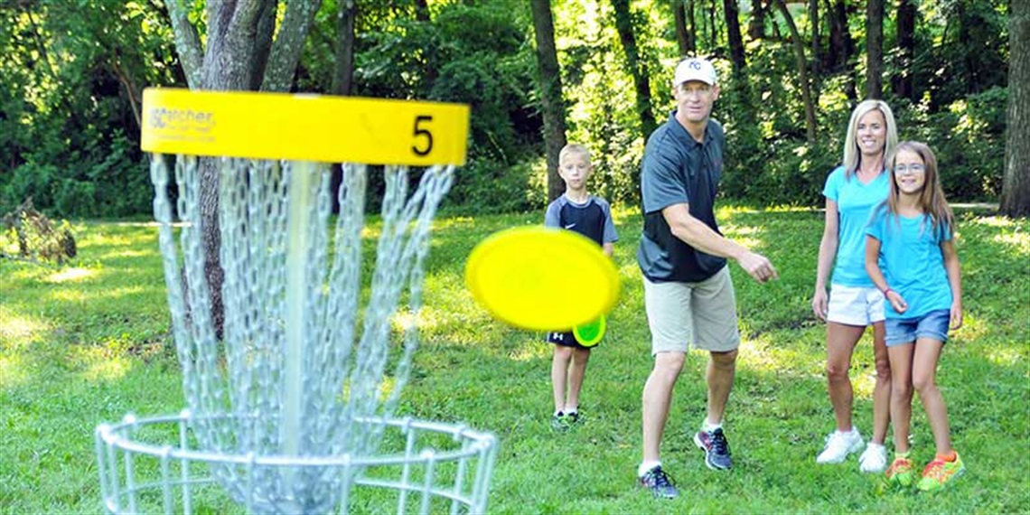 family of four playing disc golf