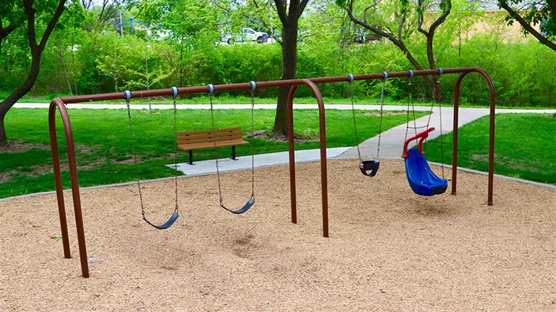 various swings and park bench at playground