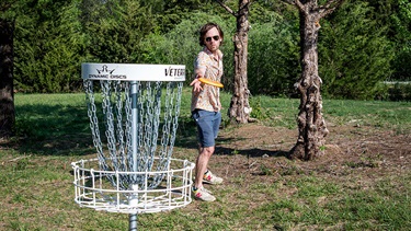 Man throwing disc near basket