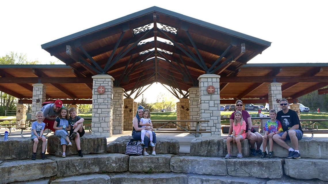 Families sitting on large stones near Oak Shelter