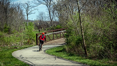 Bicyclist riding around curve on trail