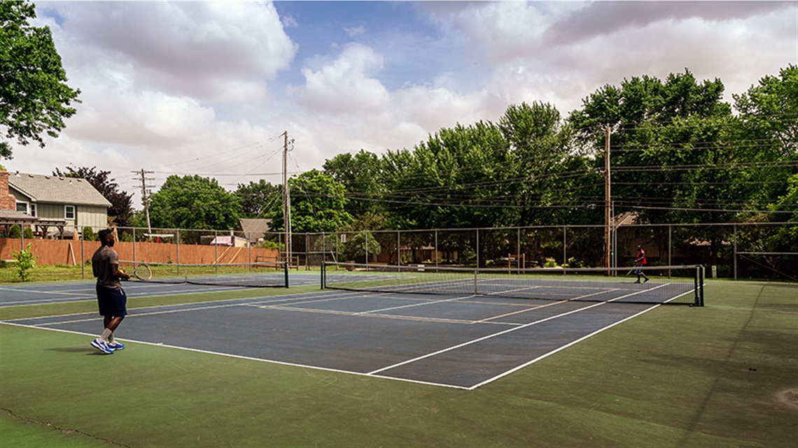 Tennis court with people playing