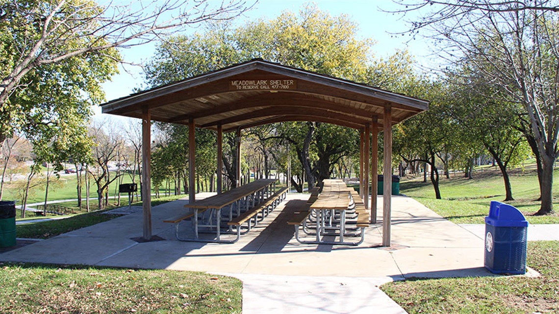 Park shelter with picnic tables and trashcans