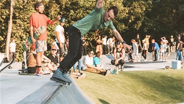 Male rollerblader balancing on spine at skate park