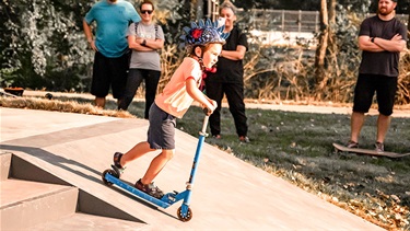 Young boy on scooter at skate park