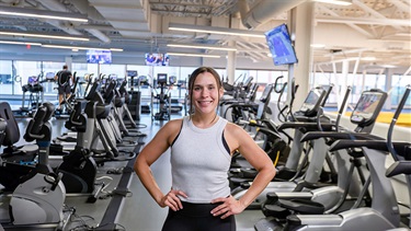 Woman standing in front of many cardio machines