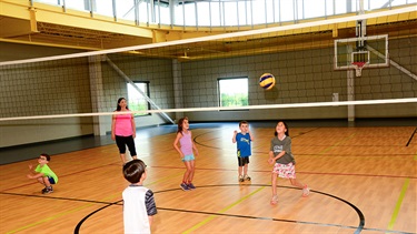 Kids playing volleyball in gym