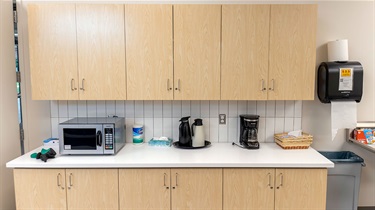 Cabinets, countertop, microwave and coffee maker in kitchen