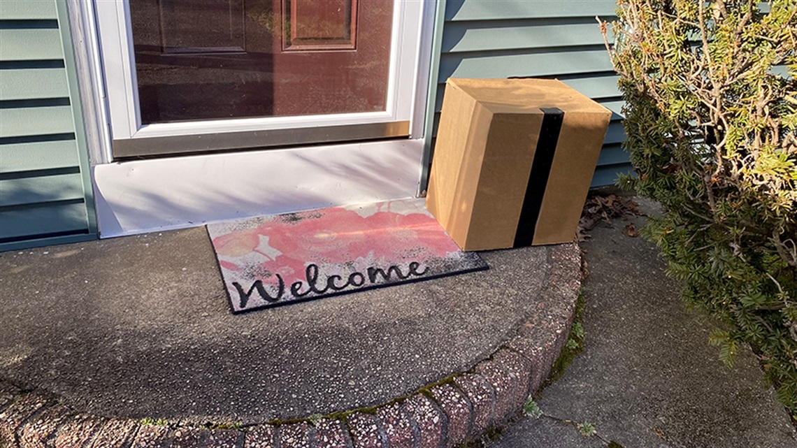 package on porch with welcome mat